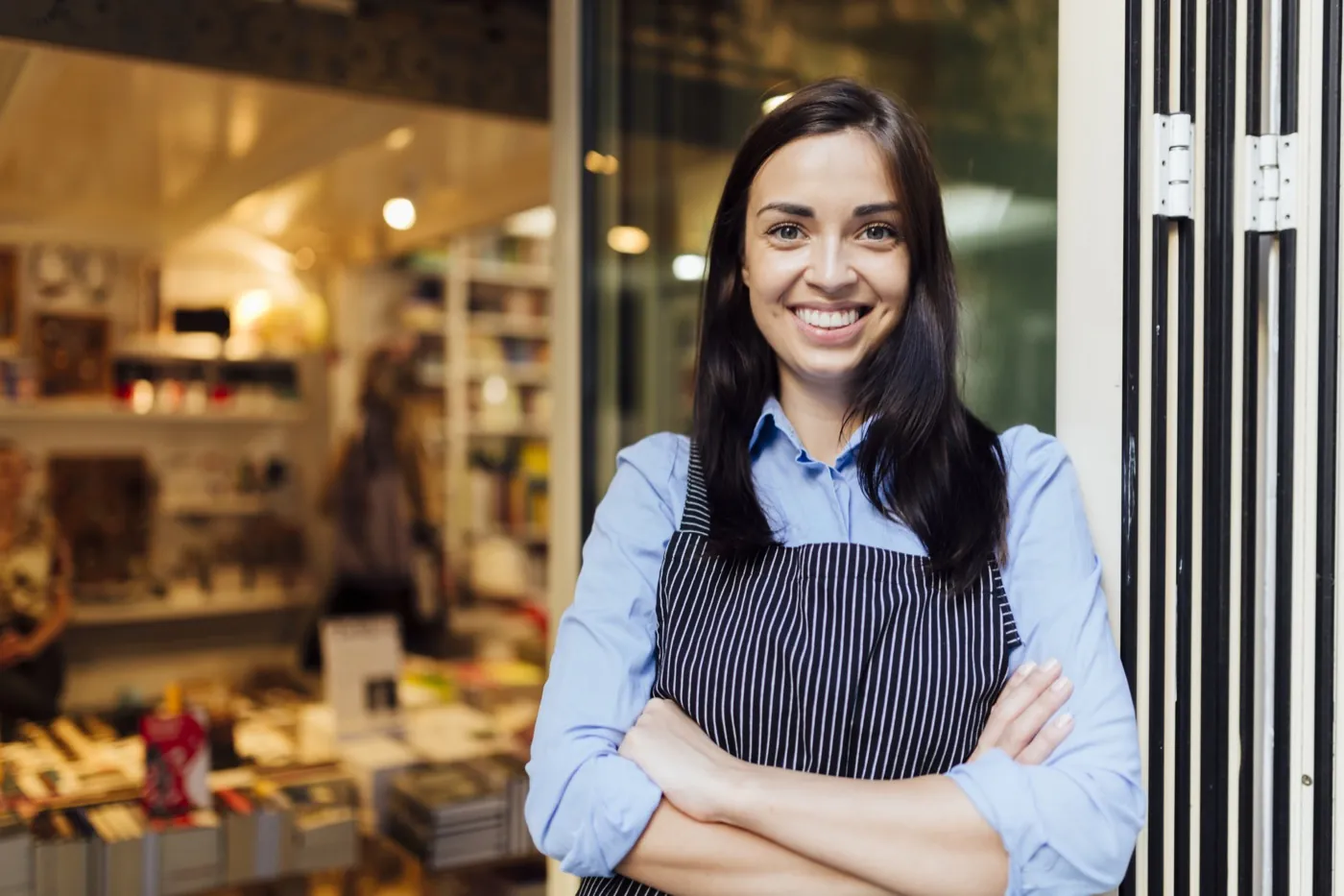 Local shop owner standing in the doorway of her store